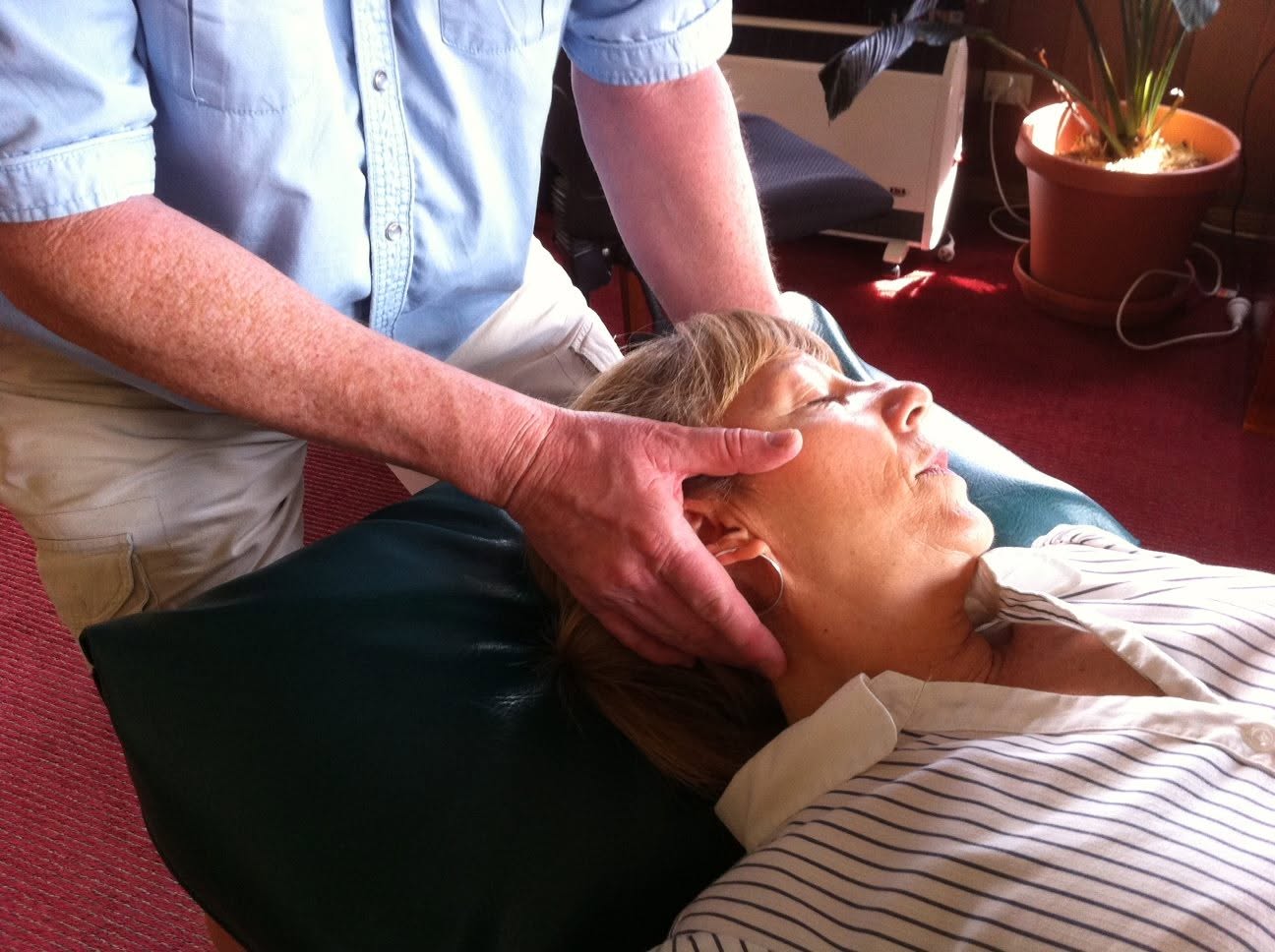 Osteopath Bruce Sutton performing neck treatment on a patient